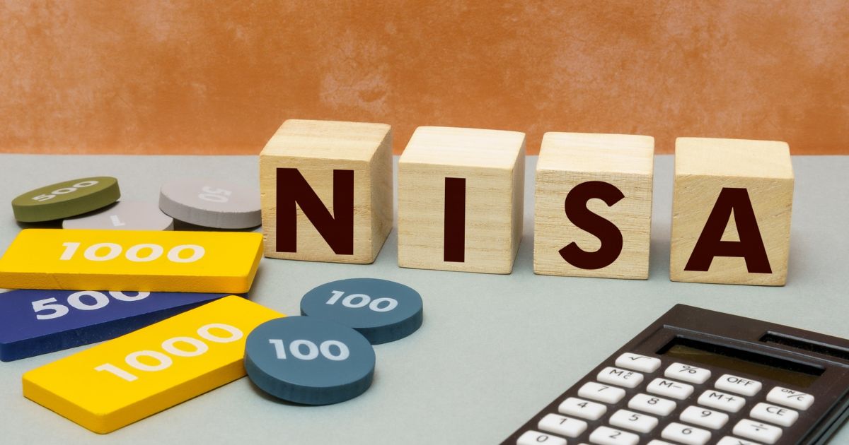 新NISAをイメージした積立額のチップと電卓、NISAの文字ブロックが並んだ写真